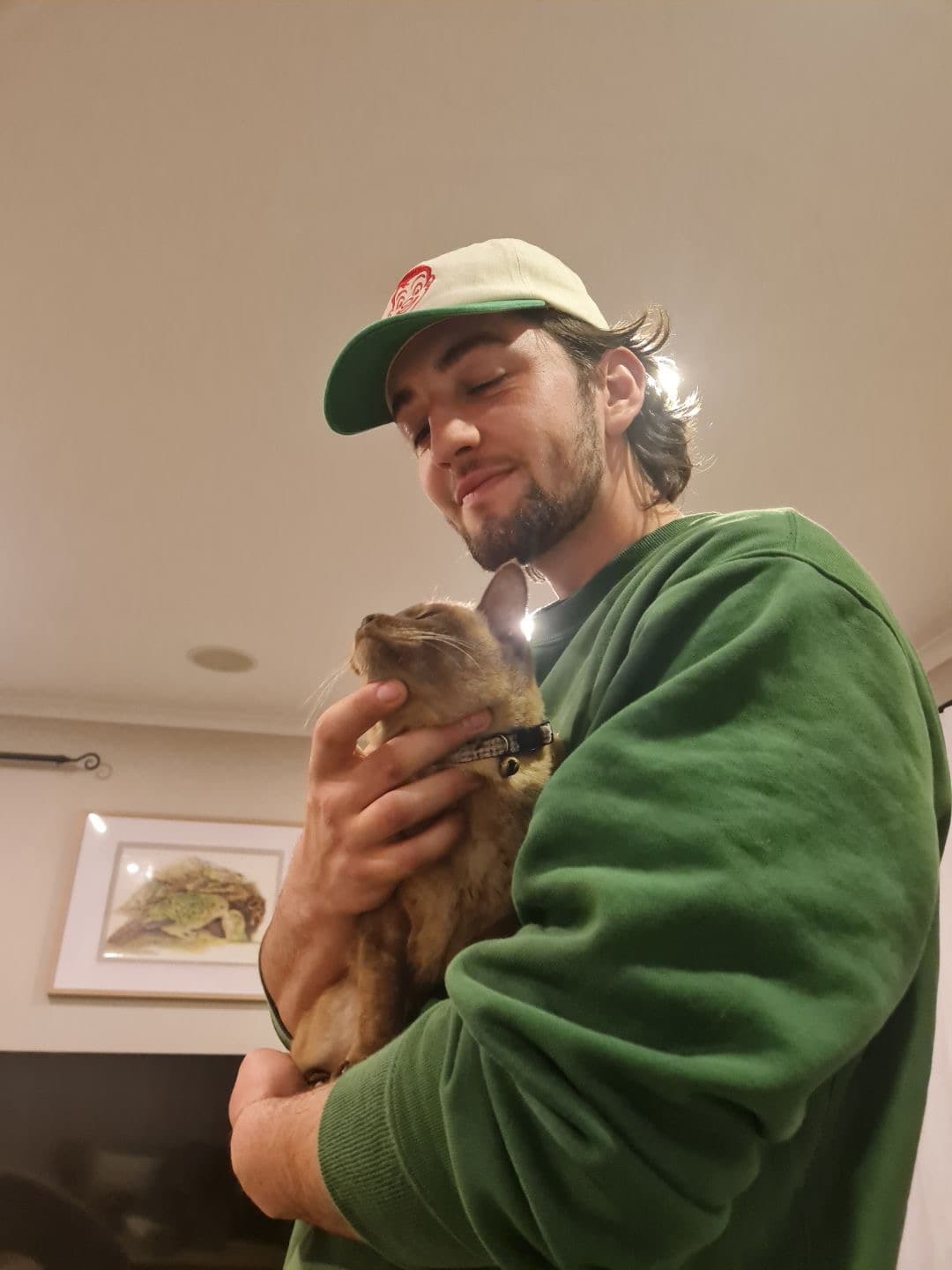 Nikau at home, holding his cat