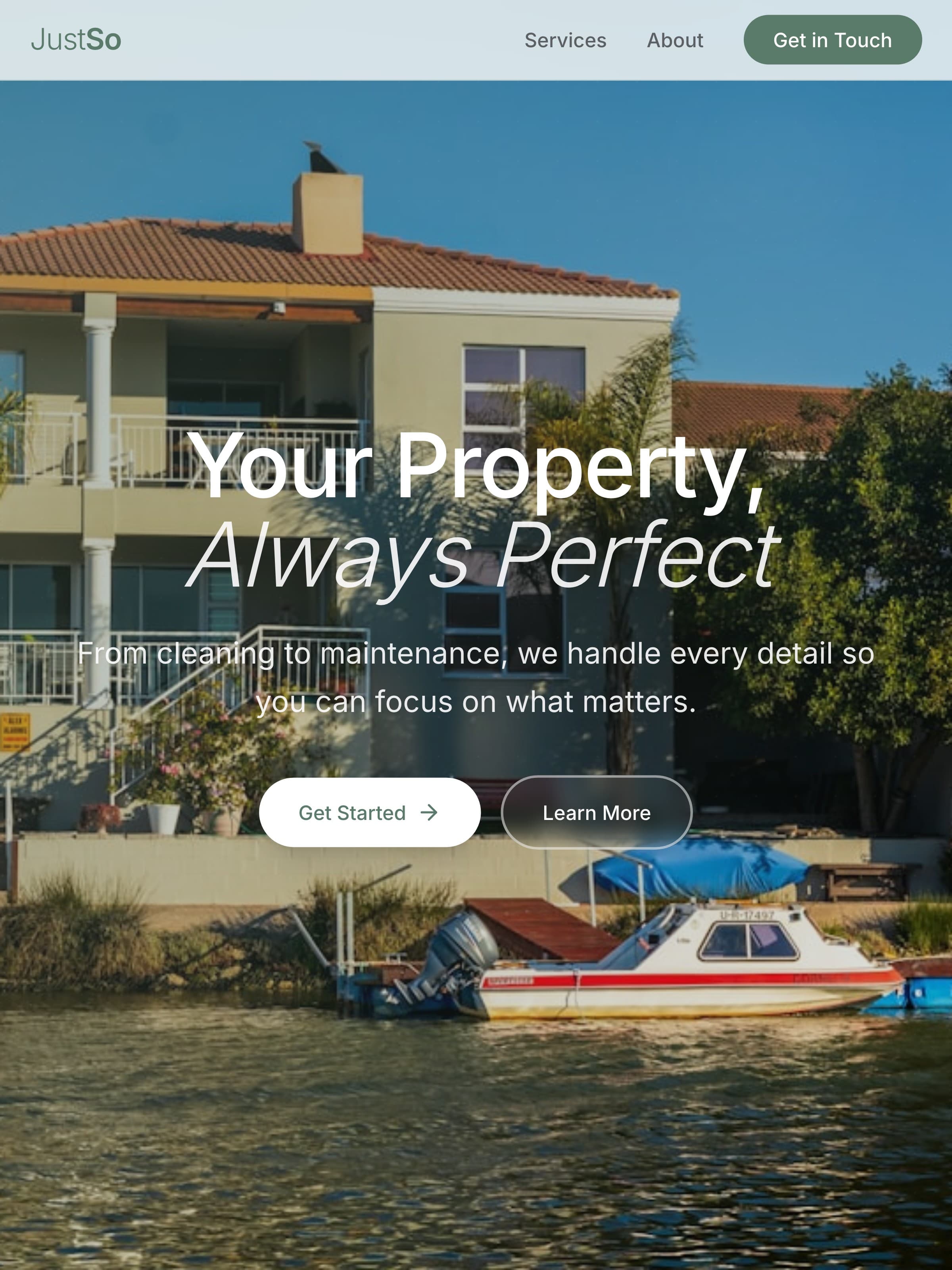 The JustSo home page held upright: “Your Property, Always Perfect” centred over the waterfront house, with “Get started” and “Learn more” below and the moored boat along the bottom.